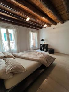 - une chambre avec un grand lit dans une pièce dotée de fenêtres dans l'établissement Ca' Del Vecio, in centro storico, Piazza Garibaldi, à Bassano del Grappa