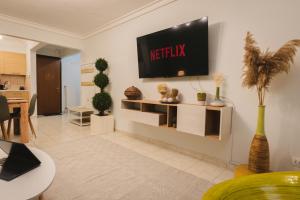 a living room with a television on a wall at Stylish apt w Jacuzzi, 10 min to White Tower in Thessaloniki