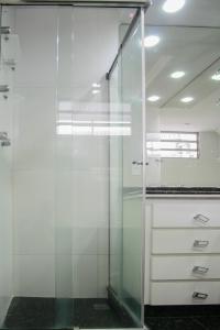y baño con ducha acristalada y armarios blancos. en 3 suítes Copacabana vista mar, en Río de Janeiro