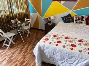 a bedroom with a bed and a table and chairs at Peru 229 Rest HOSTEL in Puno