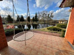 a swing on a patio with a view of a river at Willa u Bociana in Siemianówka
