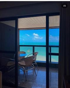 a room with a view of the ocean through a window at Iracema Flat residence in Fortaleza