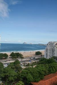 vistas a una playa con un edificio y al océano en 3 suítes Copacabana vista mar, en Río de Janeiro