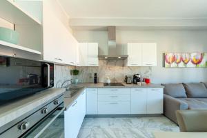 a kitchen with white cabinets and a couch at City Center near the beach in Castelsardo