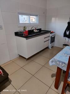 a small kitchen with a sink and a stove at Residencial Ramos in Torres