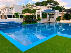 a swimming pool in front of a house at Hotel Boutique Chateau de la Mar in Juan de Acosta