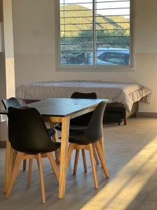 een tafel en stoelen in een kamer met een bed bij Duplex Cerró Victoria in Potrero de los Funes