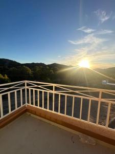 a view of the sunset from a balcony with a white railing at Duplex Cerró Victoria in Potrero de los Funes