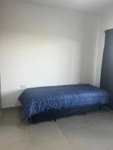 a bed in a room with a blue comforter at Duplex Cerró Victoria in Potrero de los Funes