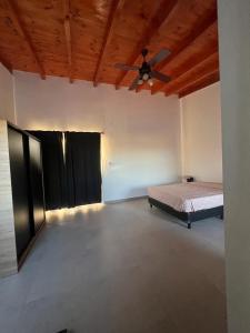 een kamer met een bed en een plafondventilator bij Duplex Cerró Victoria in Potrero de los Funes