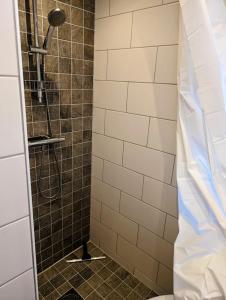 eine Dusche im Bad mit einer gefliesten Wand in der Unterkunft Mini-villa 200 m from Kämpinge beach in Höllviken