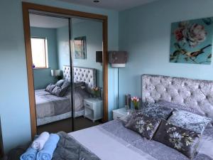 a bedroom with two beds and a large mirror at Rysa House B&B in Stromness