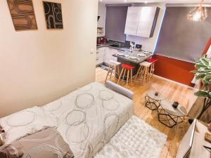 ein Wohnzimmer mit einem Bett und einer Küche in der Unterkunft Appartement de standing - coeur de Rezé / 10min de Nantes in Rezé + 23 Fotos