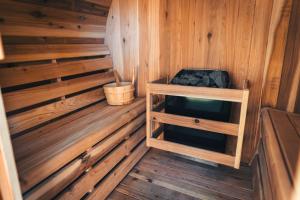 een binnenkant van een houten sauna met een kruk bij Wellnesshuis met jacuzzi en sauna in het bos in Lunteren