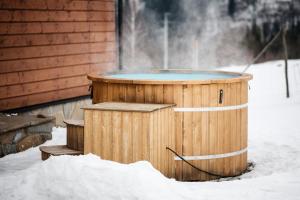 a hot tub in the snow next to a house at Na Jeżynowej Polanie z gorącą balia in Wetlina