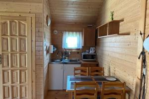 a kitchen with a table and chairs in a cabin at Holiday resort, Bobolin in Bobolin