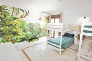 a bedroom with a bunk bed and a tropical mural at The Castle on the Hill! in Málaga +40 photos