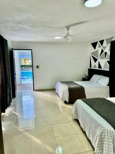1 Schlafzimmer mit 2 Betten und einer Tür zum Meer in der Unterkunft Villa Angel in Matanzas