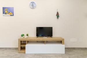 a living room with a tv on a white wall at Appartamento Belsito 15 in Misterbianco