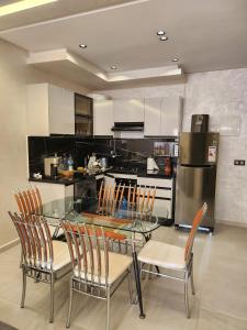 a kitchen with a glass table and four chairs at Cammar Appartement in Kenitra