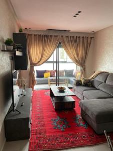 a living room with a couch and a red rug at Cammar Appartement in Kenitra