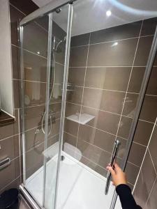 a person holding a handle in a shower at New Apartment for 8 20 mins Central London BP153 in London