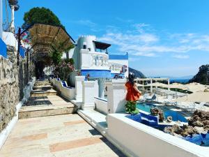 a person standing on the side of a blue and white building at ASPAT HOTEL BODRUM - Beach&Restaurant in Bodrum City