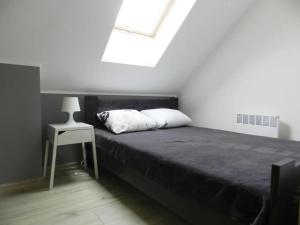 a bedroom with a bed and a table and a skylight at Domek A 134 Makowe Marzenie- Kaszubska Ostoja in Barkocin