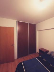 1 dormitorio con armario, cama y puerta en Dpto 1 dormitorio, 3 cuadras del Rio y de las Peatonales!, en Rosario