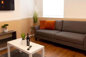 a living room with a couch and a table at Spacious 4BR Home near Liverpool CC in Liverpool