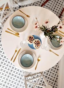 a white table with plates and bowls and flowers on it at Apartament Kety Rynek Mickiewicza in Kęty