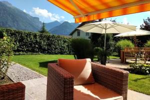 a patio with a couch and an umbrella at Vreneli in Mitlödi