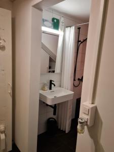 a white bathroom with a sink and a shower at Vreneli in Mitlödi