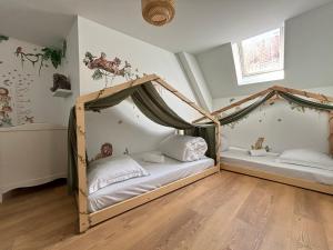 a bedroom with two beds with a canopy at Le Duplex Safari in Saint-Aignan