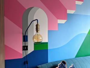a person sitting on a couch in front of a colorful wall at I Should Cocoa (York) - Seebohm in York