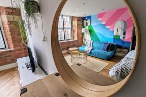 a large mirror in a living room with a blue couch at I Should Cocoa (York) - Seebohm in York