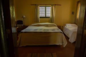 a small bedroom with two beds and a window at La Martina in Los Árboles