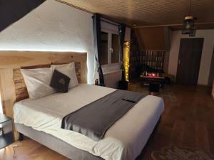 una camera da letto con un letto grande in una stanza di Chambre d'hôte de la Source Bleue a Cusance