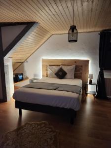 ein Schlafzimmer mit einem großen Bett in einem Zimmer in der Unterkunft Chambre d'hôte de la Source Bleue in Cusance