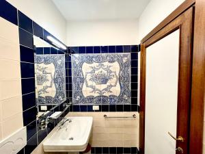 a bathroom with a sink and a blue and white tile wall at Borgia di Firenze in Florence