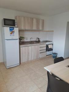 a kitchen with a white refrigerator and a sink at Departamento Alero in Goya