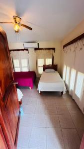 Schlafzimmer mit einem Bett und einem Deckenventilator in der Unterkunft Casa mamá Lulú in Aquismón