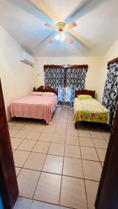 Casa mamá Lulú في Aquismón: غرفة نوم بسريرين ومروحة سقف
