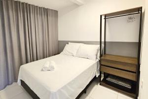 Un dormitorio con una cama con zapatos blancos. en Morada do Sol - Pé na areia!, en Florianópolis