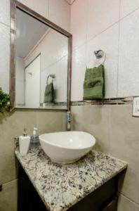 a bathroom with a sink and a mirror on a counter at Habitaciones Smith in San José