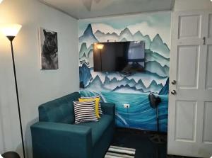 a living room with a couch and a tv on a wall at Habitaciones Smith in San José