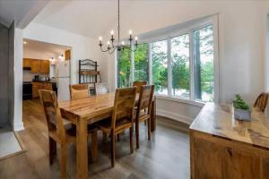 a kitchen and dining room with a wooden table and chairs at Gorgeous Muskokan Cottage on Six Mile Lake in Port Severn