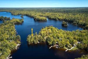 eine Insel mit einem gelben Turm in der Mitte eines Sees in der Unterkunft Gorgeous Muskokan Cottage on Six Mile Lake in Port Severn + 6 Fotos