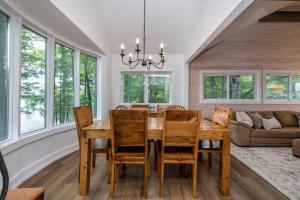 a dining room with a wooden table and chairs at Gorgeous Muskokan Cottage on Six Mile Lake in Port Severn
