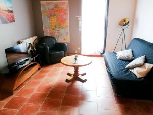a living room with a blue couch and a table at Maison de ville avec garage privé Sées chez Nous in Sées